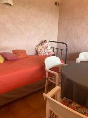 a room with a bed with pillows and a table and chairs at Appartement Marina di santa giulia in Porto-Vecchio