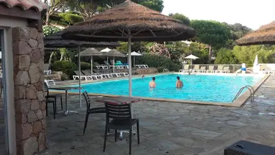 two people in the swimming pool at a resort at Appartement Marina di santa giulia in Porto-Vecchio