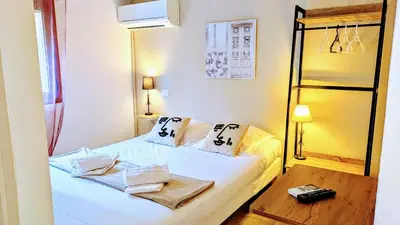 a small bedroom with a white bed with two pillows at Auberge de Cannedda in Sari Solenzara