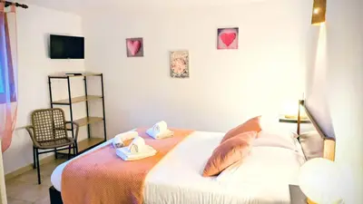 a bedroom with a bed with two towels and a chair at Auberge de Cannedda in Sari Solenzara