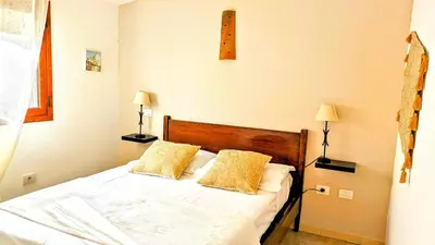 a bedroom with a white bed with two yellow pillows at Auberge de Cannedda in Sari Solenzara