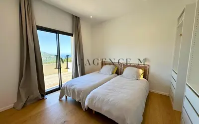 a bedroom with a bed and a large window at Villa Giuliana Paisible & spacieuse AREGNO in Aregno