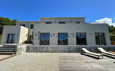 a building with two white chairs in front of it at Villa Giuliana Paisible & spacieuse AREGNO in Aregno