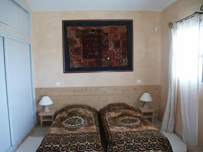 a bedroom with two beds and a picture on the wall at BLU DI MARE Palombaggia in Porto-Vecchio
