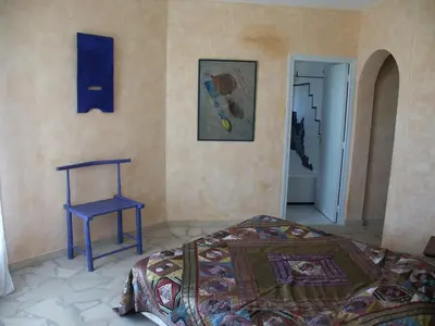 a bedroom with a bed and a table and a chair at BLU DI MARE Palombaggia in Porto-Vecchio