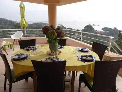 a table with a yellow table cloth on a balcony at BLU DI MARE Palombaggia in Porto-Vecchio