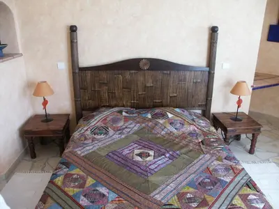 a bedroom with a large bed with two tables at BLU DI MARE Palombaggia in Porto-Vecchio