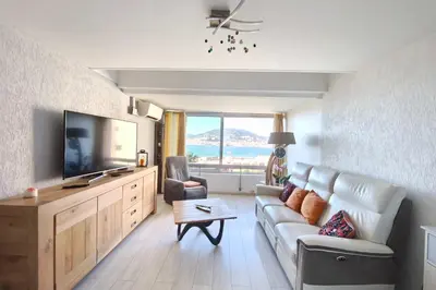 a living room with a couch and a flat screen tv at Bright apartment 3 minutes from the beach in Ajaccio