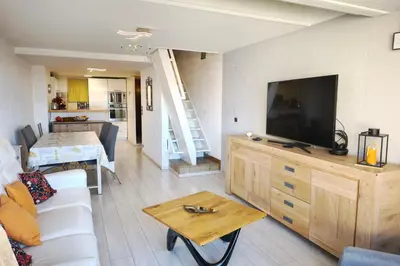 a living room with a couch and a tv and a table at Bright apartment 3 minutes from the beach in Ajaccio