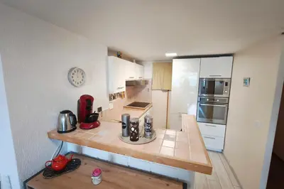 a small kitchen with a counter and a refrigerator at Bright apartment 3 minutes from the beach in Ajaccio
