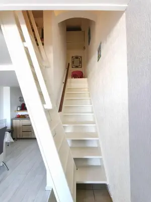 a staircase in a house with white walls at Bright apartment 3 minutes from the beach in Ajaccio