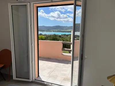 a sliding glass door with a view of the ocean at Mini villa en duplex vue mer à 500 m de la plage de Santa Giulia in Porto-Vecchio