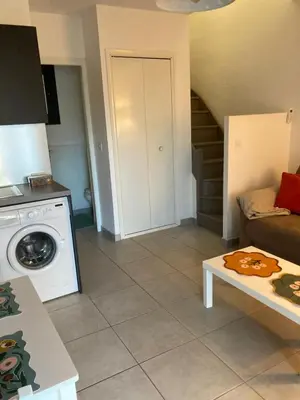 a living room with a couch and a washer at Mini villa en duplex vue mer à 500 m de la plage de Santa Giulia in Porto-Vecchio