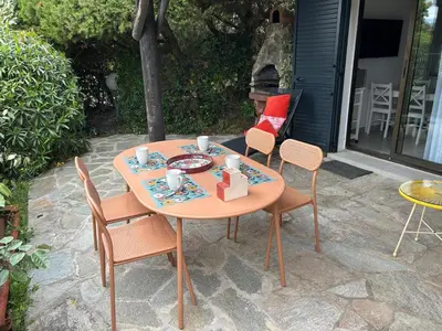 a table and chairs on a patio with a meal on it at Mini villa en duplex vue mer à 500 m de la plage de Santa Giulia in Porto-Vecchio