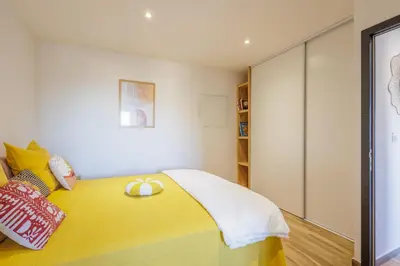 a bedroom with a yellow bed with two rings on it at La Casa Di Castagni - Climatisé avec terrasse in Oletta