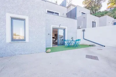a white house with a patio with blue chairs at La Casa Di Castagni - Climatisé avec terrasse in Oletta