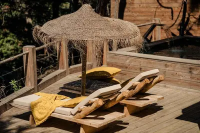an umbrella and lounge chairs on a wooden deck at Lagnonu in Verghia