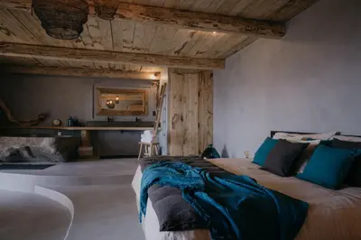 a bedroom with a large bed with a wooden ceiling at Lagnonu in Verghia