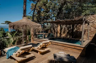 a hot tub on a wooden deck with a umbrella at Lagnonu in Verghia