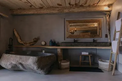 a large rock tub in a bathroom with a mirror at Lagnonu in Verghia