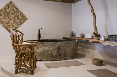 a bathroom with a large stone tub and a chair at Lagnonu in Verghia