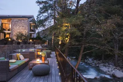 a deck with a couch and a table and a river at Dominique Colonna in Corte