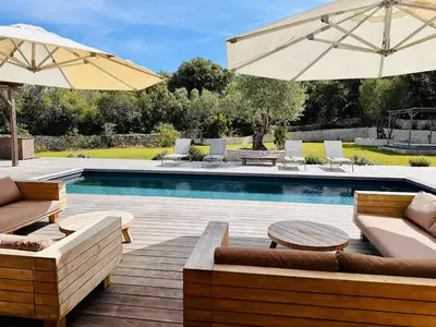a swimming pool with chairs and umbrellas next to a pool at Villa Dina - Douceur et calme in Bonifacio