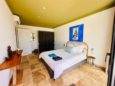 a bedroom with a bed and a desk in it at Villa Dina - Douceur et calme in Bonifacio