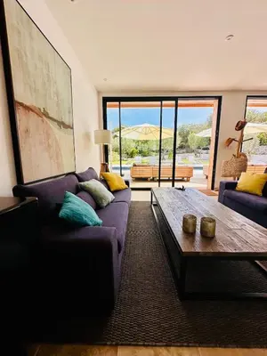 a living room with a purple couch and a coffee table at Villa Dina - Douceur et calme in Bonifacio