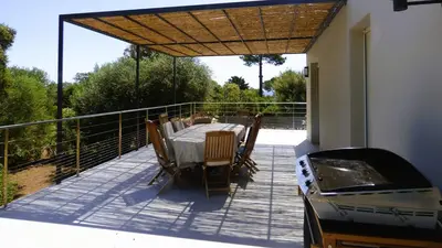 a patio with a table and chairs on a balcony at Villa Stella Diana, 12 pers, 100 m plage in Pinarellu