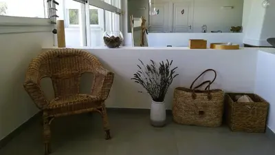 a kitchen with a chair and a counter with baskets at Villa Stella Diana, 12 pers, 100 m plage in Pinarellu