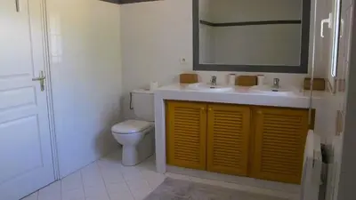 a bathroom with a toilet and two sinks and a mirror at Villa Stella Diana, 12 pers, 100 m plage in Pinarellu