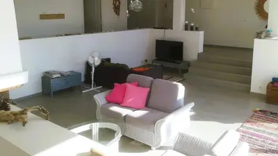 a living room with a couch with two pink pillows at Villa Stella Diana, 12 pers, 100 m plage in Pinarellu