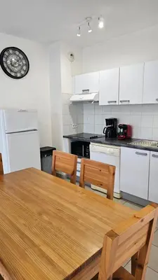 a kitchen with a wooden table and chairs at T3 résidence privée proche plage et piscine in Poggio-Mezzana