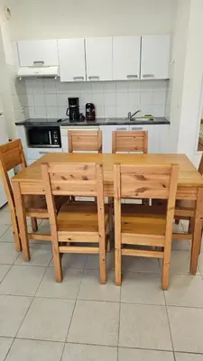 a wooden table and chairs in a kitchen at T3 résidence privée proche plage et piscine in Poggio-Mezzana
