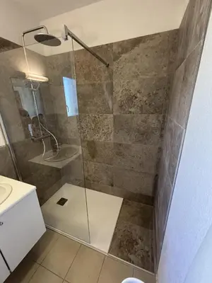 a shower with a glass door in a bathroom at T3 résidence privée proche plage et piscine in Poggio-Mezzana