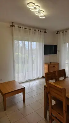 a living room with a dining room table and chairs at T3 résidence privée proche plage et piscine in Poggio-Mezzana