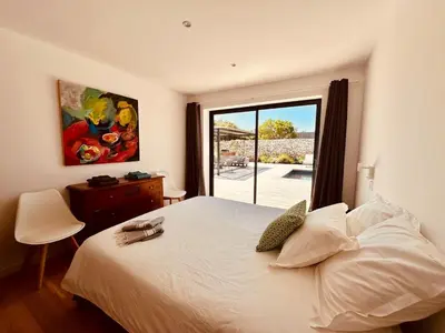 a bedroom with a white bed and a large window at Villa Gioia- Charme et sérénité in Bonifacio