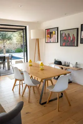a dining room with a wooden table and white chairs at Villa Gioia- Charme et sérénité in Bonifacio