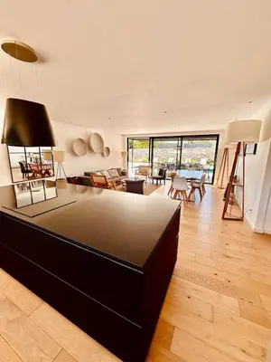 a large living room with a large black couch at Villa Gioia- Charme et sérénité in Bonifacio