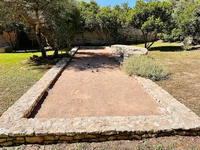 a garden with a stone wall and a tree at Villa Gioia- Charme et sérénité in Bonifacio