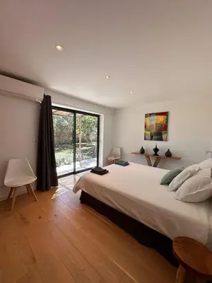 a bedroom with a large bed and a large window at Villa Gioia- Charme et sérénité in Bonifacio
