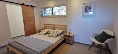 a bedroom with a bed and a chair and a window at Casa PETRA et FIORI, une bergerie en pierres authentiques toute équipée - 4 personnes in Pietrosella