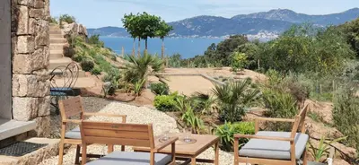 a patio with two chairs and a table at Casa PETRA et FIORI, une bergerie en pierres authentiques toute équipée - 4 personnes in Pietrosella