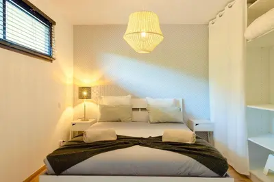 a bedroom with a large bed with a chandelier at Villa Maquis, Vue mer, élégante maison au calme, 80m2, 4 personnes in Pietrosella