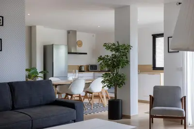 a living room and kitchen with a table and chairs at Villa Maquis, Vue mer, élégante maison au calme, 80m2, 4 personnes in Pietrosella