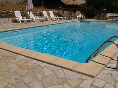 a swimming pool with chairs and an umbrella at Auberge - Hotel U Paradisu in Vico