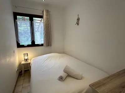 a small bedroom with a white bed and a window at Résidence Capizzolu in Cargèse