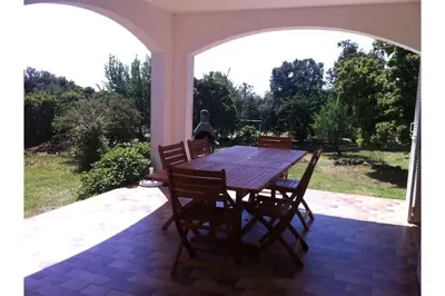 a wooden table and chairs on a patio at Villa climatisée, superbe vue mer in Ventiseri