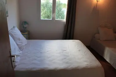 a bedroom with a white bed and a window at Villa climatisée, superbe vue mer in Ventiseri